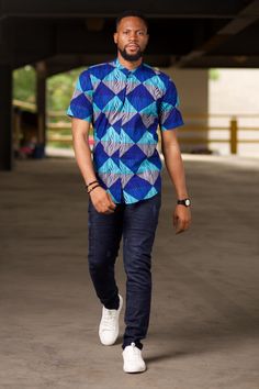 Step up your casual wardrobe with our Aire African Print Men's Shirt, a perfect fusion of tradition and modern style. This handmade shirt features a striking Ankara print in a geometric pattern, adding a touch of vibrant African culture to your look. The short sleeve design and concealed buttons make it ideal for warm weather, while the comfortable cotton fabric ensures all-day ease. Whether you're dressing up for a casual outing or keeping it simple at home, this shirt is versatile enough to su Modern Short Sleeve Patterned Shirt, Modern Printed Cotton Shirt, Modern Multicolor Cotton Shirt, Casual Fitted Shirt With Geometric Pattern, African Print Mens Shirt Ankara Styles, Cotton Shirt With Relaxed Fit And Geometric Pattern, Blue Cotton Tops With Geometric Pattern, Cotton Shirt With Geometric Pattern And Relaxed Fit, Relaxed Fit Cotton Shirt With Geometric Pattern