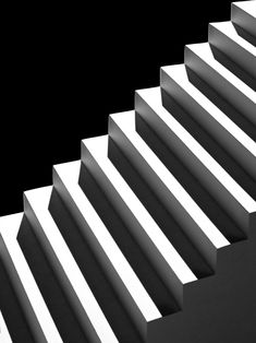 a black and white photo of stairs with light coming through the top one on each side