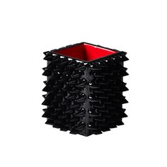 a black and red vase sitting on top of a white wall