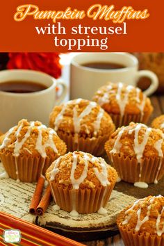 pumpkin muffins with streusel topping on a plate next to two cups of coffee