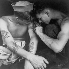 two men with tattoos sitting next to each other