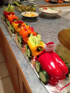 a train made out of vegetables sitting on top of a counter next to other foods