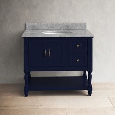 a bathroom vanity with a marble top and two drawers on the bottom, against a gray wall