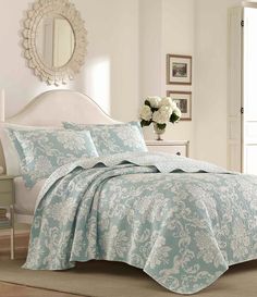 a bed with a blue comforter and white flowers