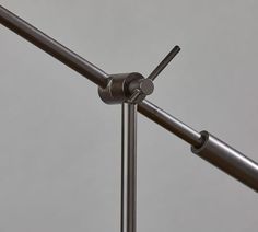 a metal pole with two poles attached to it and an object in the background that appears to be part of a sculpture