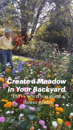 a woman standing in the middle of a flower garden