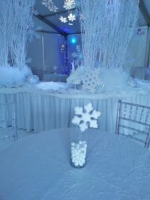 a vase filled with white candy sitting on top of a table covered in snowflakes