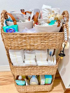 a wicker basket filled with lots of baby items on top of a hard wood floor