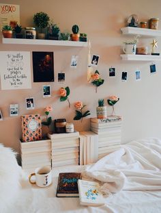 a bed room with a neatly made bed and lots of pictures on the wall above it