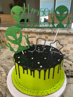 a green and black cake sitting on top of a counter