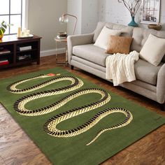 a living room area with a couch, chair and rug on top of the floor