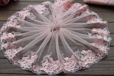 a pink lace doily sitting on top of a wooden table