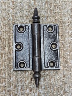 an image of a door hinge that is on the floor with carpet in the background