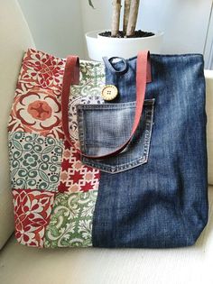 a bag made out of jeans and fabric with a flower pot in the back pocket