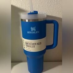 a blue travel mug with a straw in it