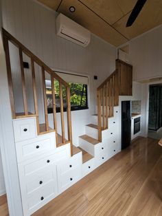 an empty room with stairs and cabinets