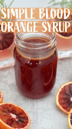 blood orange syrup in a mason jar surrounded by sliced blood oranges