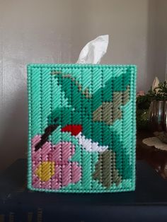 a tissue dispenser made out of bead and plastic beads with an image of a bird on it