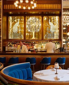 a man sitting at a bar with blue chairs