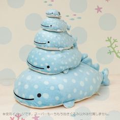 a stuffed whale is stacked on top of each other in front of a polka dot wall