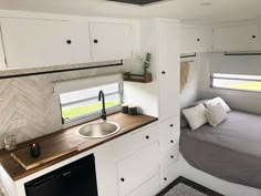 a small kitchen and bed in a trailer