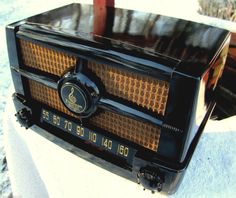 an old fashioned radio sitting on top of snow covered ground