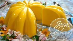 two pieces of yellow cake sitting on top of a glass plate with flowers around it