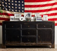 an american flag hanging over a dresser with pictures on it