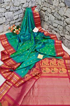 A pure enigmatic collection in golden color with the golden buti and silver zari border, with peacock motif on the pallu and meenakari butta work on spread across the saree in plaintive for, done in the traditional handloom style makes it a classic choice of many. Color: A shade of dual tone blue and green color Technique: Amazing work of golden zari buti work on the body with traditional weaving Fabric: Paithani Quality: Indyvogue's Assurance of Pure Silk Mark Certified Saree Green Raw Silk Traditional Wear With Meenakari, Green Meenakari Raw Silk Traditional Wear, Green Traditional Wear With Meenakari In Raw Silk, Traditional Meenakari Katan Silk Wear For Festivals, Traditional Katan Silk Wear With Meenakari For Festivals, Meenakari Katan Silk Traditional Wear For Festivals, Paithani Silk Traditional Wear For Diwali, Traditional Meenakari Saree For Festivals, Green Meenakari Traditional Wear For Transitional Season