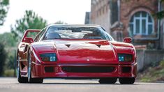 a red sports car parked in front of a brick building