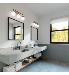 a bathroom with two sinks and three mirrors