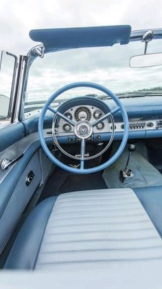 the interior of an old car with blue leather