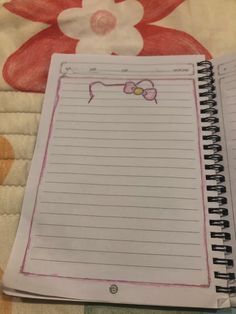 an open notebook sitting on top of a bed next to a teddy bear and flower