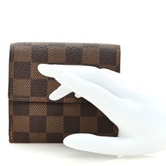 This is an authentic LOUIS VUITTON Damier Ebene Elise Wallet. This stylish wallet is crafted of Louis Vuitton signature damier check canvas. The wallet opens with a flap and a snap to a currency compartment and a flap on the reverse to a brown cross-grain leather interior of card slots, patch pockets and a billfold. Louis Vuitton Damier Ebene, Damier Ebene, Leather Interior, Authentic Louis Vuitton, Louis Vuitton Damier, Card Slots, Slots, Grain, Louis Vuitton