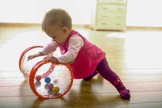 a baby playing with a toy on the floor