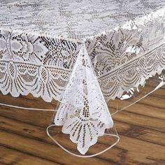 an image of a table with white lace on it and wood flooring in the background