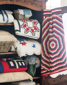 pillows and blankets are stacked on shelves in a room