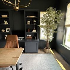 a home office with black walls and wooden desks, built in shelving units