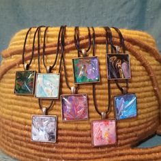 Charming, one of a kind wearable art necklaces. Proudly personalize your look with a handmade piece of art. Unique and colorful acrylic skins on 1 1/8" square pendants protected by glass cabochon's.  Your choice of matching chain, matching cotton cord (18" only) or black waxed cotton cord, 16" or 18" in length, with lobster claw clasp. Don't forget to choose your options before checkout. These make perfect charming and affordable gifts. Be sure to check back often as the colors and designs change regularly Hand Painted Resin Pendant Necklaces, Artistic Resin Necklace With Round Pendant, Spiritual Multicolor Cabochon Necklace, Unique Iridescent Cabochon Necklaces, Artistic Resin Pendant Necklace, Square Pendant, Affordable Gifts, Waxed Cotton, Wearable Art