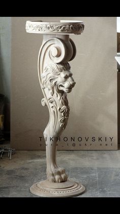 a white marble pedestal with a lion head on it's base and an ornate design