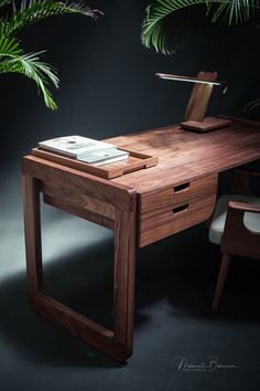 a wooden desk with a phone on it next to a chair and potted plant