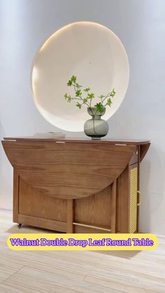 a wooden table with a vase on top and a mirror above it that says walant double drop leaf round thing