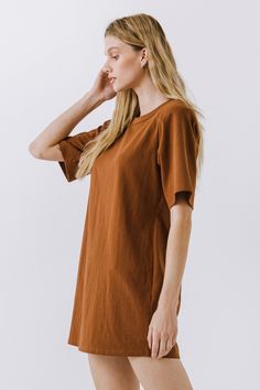 This Shoulder Pad T-Shirt Dress is a wardrobe must-have! Featuring a stylish round neckline, short sleeves, and a boxy silhouette, it's the perfect addition to any outfit. Our unique shoulder pad insert adds structure and a touch of sass, making this dress a standout. With its comfortable fit and comfortability, you'll look amazing no matter what the occasion. Show off your fashion-forward style with this shoulder-pad t-shirt dress! Shoulder pad inserted Round neckline Short sleeves Boxy silhoue Fall Relaxed Fit Short Sleeve T-shirt Dress, Summer Dress With Side Slits And Crew Neck, Summer Dresses With Side Slits And Crew Neck, Brown Oversized Short Sleeve Dress, Summer Short Sleeve T-shirt Dress For Everyday, Relaxed Fit Short Sleeve T-shirt Dress For Fall, Solid Color Short Sleeve Everyday Dresses, Everyday Solid Color Dress With Short Sleeves, Solid Color Cotton T-shirt Dress With Crew Neck