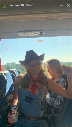 a woman wearing a cowboy hat sitting in the back of a car holding a drink