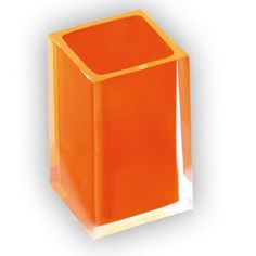 an orange square vase sitting on top of a white table