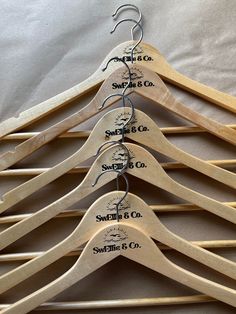 the wooden hangers are labeled with names for each type of coat or suit on display