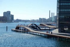 people are walking on the bridge over the water