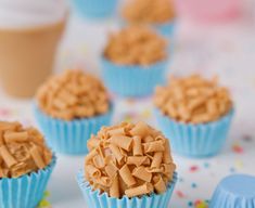 cupcakes with frosting and sprinkles sitting on a white table