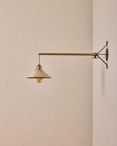 an old fashioned wall light hanging on the side of a white wall next to a lamp