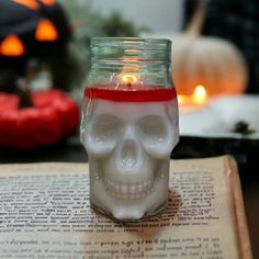 a skull candle is sitting on top of an open book